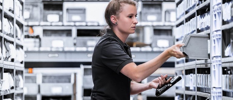 Bild einer Mitarbeiterin von Scherzinger im Ersatzteilelager für idealen Ersatzteileservice.